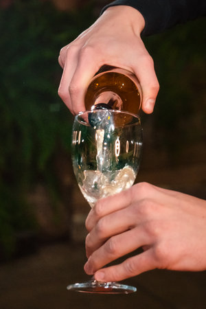 the pouring of fruit cider into a glass on the dark backroundの写真素材