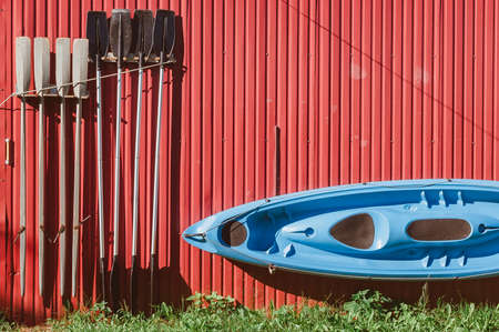 The kayak and paddles are hanging on the wall to dry. Storage of water sports and tourist equipmentの素材 [FY310181342484]