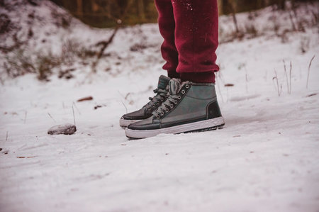 the legs of a person standing on a snowy winter pathの写真素材