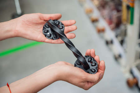 Elegant forged door handle in the hands of a girl. A separate metal black handle in a hardware store