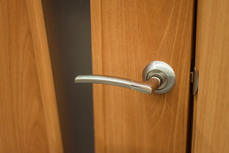 Silver handle on a wooden door with glass. Interior door with a gray metal knobの写真素材