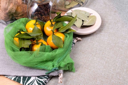 Composition of fresh mandarins with linen and reusable bags and glass jars.の写真素材