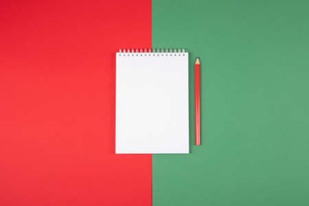 New Year plans or dreams sketchbook with a pencil on red and green background.の写真素材