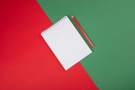 New Year plans or dreams sketchbook with a pencil on red and green background.の写真素材