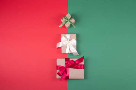 Beautiful packaging of presents with satin ribbons, craft paper on red and green background.の写真素材