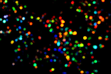 Beautiful and festive multicoloured blurred lights on black background.の写真素材