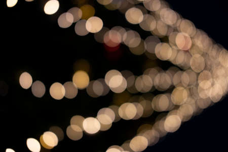 Beautiful bokeh gold lights of the festive New Year tree in the city.の写真素材