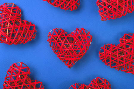 Beautiful pattern of the red wicker hearts on the cornflowerblue background. St Valentine's concept for your design.の写真素材
