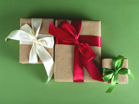 Beautiful packaging of presents with multicolor satin ribbons, craft paper on the green background.の写真素材