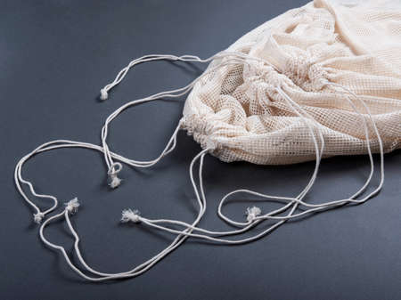 Three reusable string bags for fruits, vegetables, grocery or other products on the grey background, closeup.の写真素材