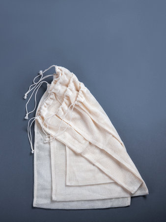 Three white zero waste string sacks for fruits, vegetables, grocery or other products on the grey background with the empty space for your text.の写真素材