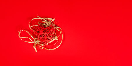 St Valentines concept as a red heart as if in the nest on the red background with copy space. Flatlay, banner.の写真素材