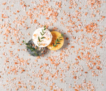The beautiful picture of the round natural handmade soaps and bath salt with the twigs of eucalyptus on the cotton background with the copy space. Zero waste concept of bathing without any package.の写真素材