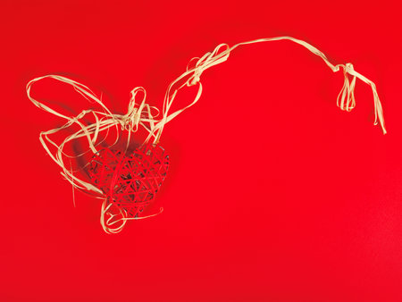 St Valentines concept as a red heart as if in the nest on the red background with copy space....
