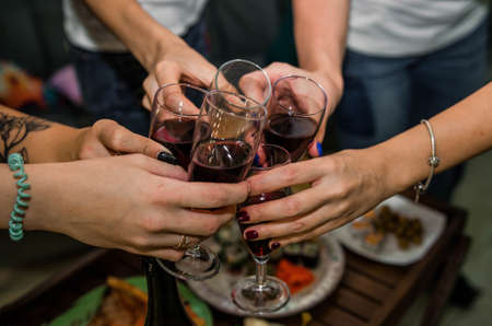 Cheerful friends clinking glasses above dinner table.の写真素材