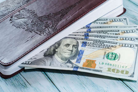 Closed notebook for notes with money on the tableの写真素材