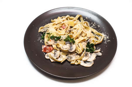 Pasta with mushrooms on a plate on a white backgroundの写真素材