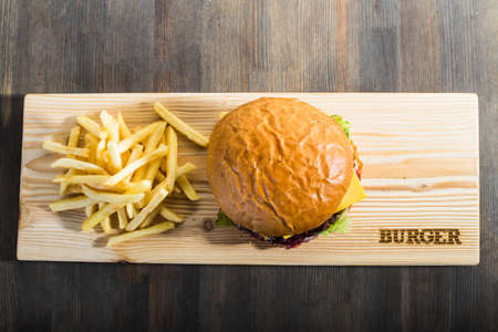 crafting a burger on the board with friesの写真素材