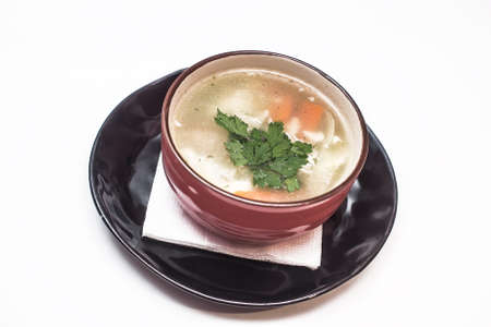 Soup with vegetables and meatballs in the black bowl isolated.の写真素材