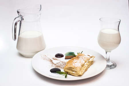 Apple pie with a decanter and a glass of milk on a white backgroundの写真素材