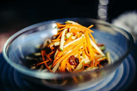 Green salad with lettuce, carrot and onion on the plate closeの写真素材