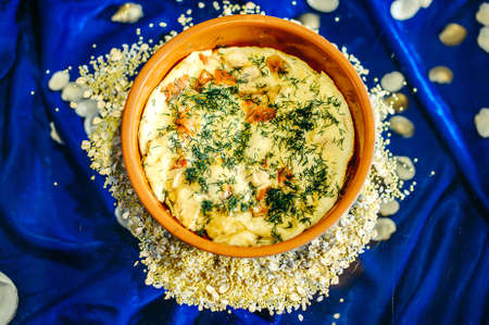 Omelette in a bowl on a table with a blue backgroundの写真素材