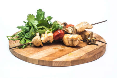 Shish kebab from chicken champignons and tomatoes on a white backgroundの写真素材