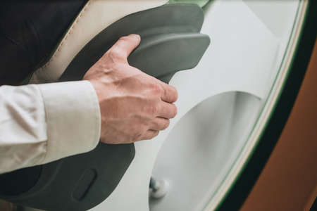 Hand on the arm of a man sitting in a medical chair close from aboveの写真素材