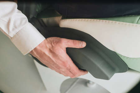 Hand on the arm of a man sitting in a medical chair close another viewの写真素材
