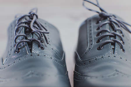 Stylish gray man's crafted shoes for ballroom dancing with laces from skin and suede on the wooden background. photography of men's gray boots for ballroom dancing. macro in front viewの写真素材