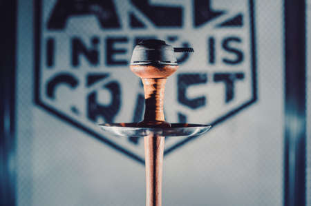 Crafted hand-made hookah stands on a wooden table in a hookah cafe on the background of the art...