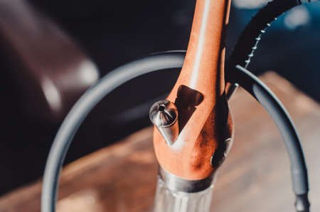 Crafted hand-made hookah stands on a wooden table in a hookah cafe on the background of the art wall. wooden shaft of hookah another view closeの写真素材