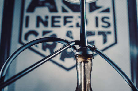 Crafted hand-made hookah stands on a wooden table in a hookah cafe on the background of the art...