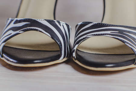 hand-made women's dance shoes made of genuine leather on the wooden surface macro photography. black and white as a zebra style. closeの写真素材