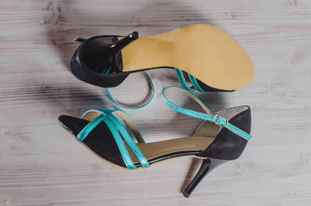 hand-made women's dance shoes made of genuine leather on the wooden surface macro photography. turquoise and black colored style closeの写真素材