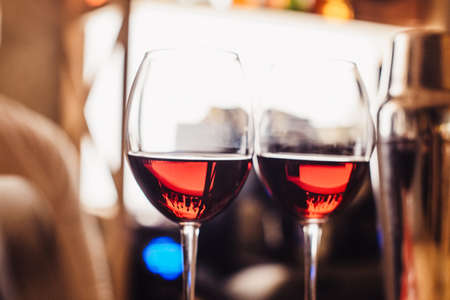 Two glasses of wine on the counter in the light of the barの写真素材