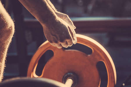 Male powerlifter hand in talc. preparation before lifting weights. Toned image. Hands in chalk. With...