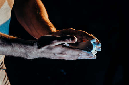 Male powerlifter hand in talc. palm preparation before lifting weights. Toned image. Hands in chalkの写真素材