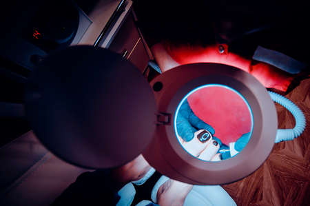 The process of pedicure in a professional beauty salon. Toned image. hardware processing of toes. from the top viewの写真素材