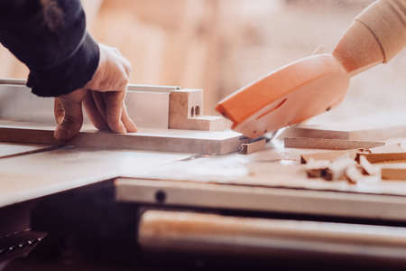 A carpenter works on woodworking the machine tool. Toned image.の写真素材
