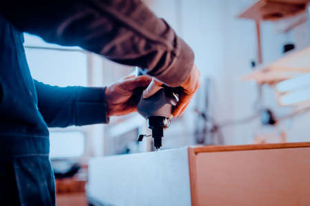 Man builds furniture in the carpentry shop. Toned image.の写真素材