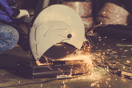 Worker cutting metal. Cutting metal angle grinder. Toned image. shearing metal parts metal sparks closeの写真素材