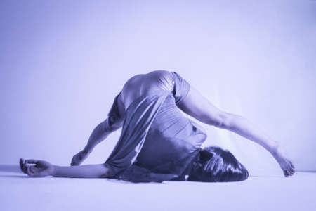 Modern teen contemporary dancer poses in front of the studio background with the hard light. Toned...
