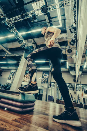 Man doing step up jumps in health club. Toned image.のeditorial素材