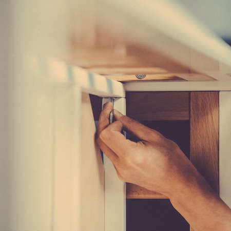 Joiner collects a new baby cot with a hand tool. carpenter collects a cot. Toned image. collects the walls of the crib using a hand hexagon. fixes the bottom of the crib to its walls. close upの写真素材