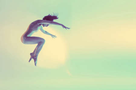 Modern teen contemporary dancer poses in front of the studio background. Toned image. Like a doll view. bounce view with copy spaceの写真素材