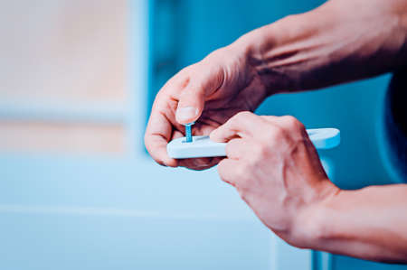 Joiner collects a new baby cot with a hand tool. carpenter collects a cot. Toned image. collects the walls of the crib using a hand hexagon. fixes the pendulum of a cotの写真素材