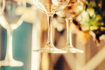 Party concept. Many clean washed glasses for wine on the bar with blurred background. Toned image. close up view with blurred backgroundの写真素材
