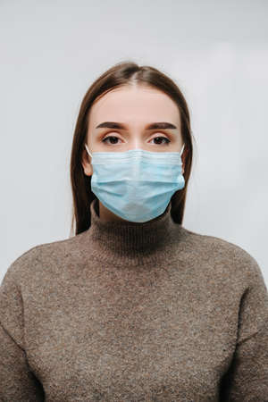 Girl in a medical mask on a background of a brick wall