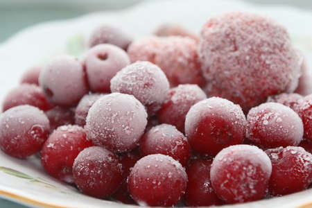 Frozen cherries and strawberries on a white plateの写真素材